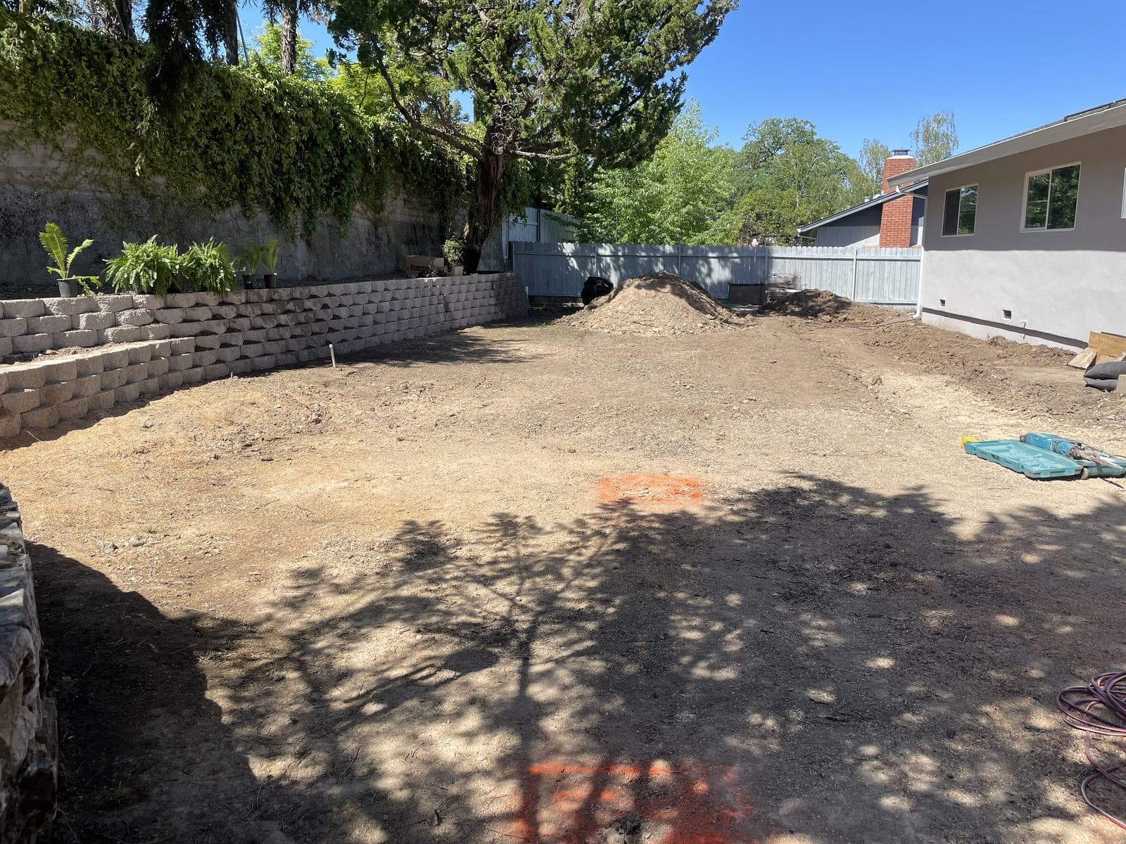 Ninety-foot segmental block retaining wall, three and a half feet tall with a stepped second tier, creating a flat back yard